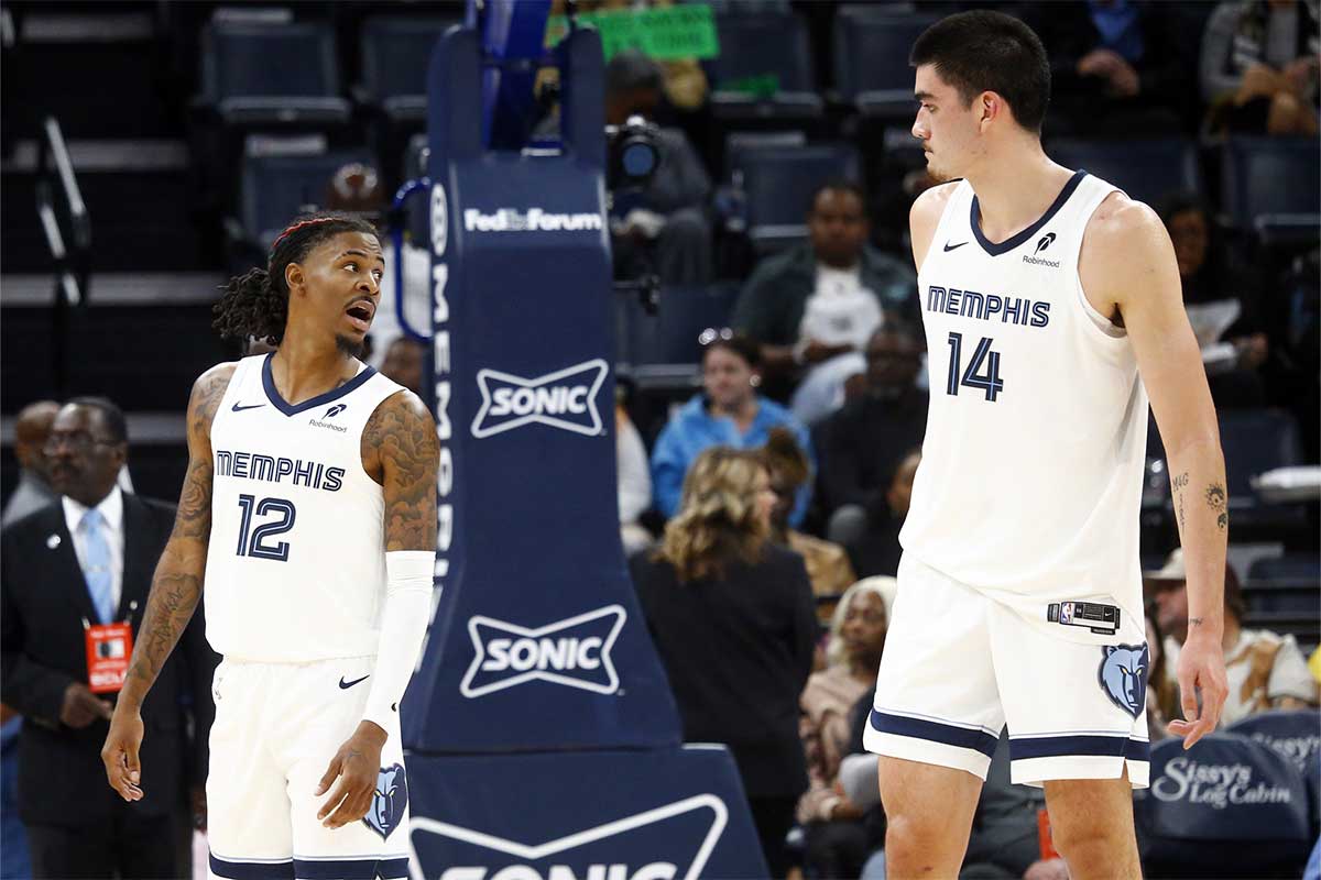 Memphis Grizzlies guard Ja Morant (12) talks with center Zach Edey (14) during a time-out during the second half against the Miami Heat at FedExForum.