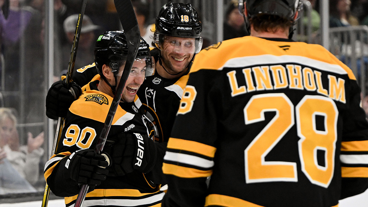 Boston Bruins forward Tyler Johnson celebrates with center Pavel Zacha (18) and center Elias Lindholm (28) after scoring a goal against the Philadelphia Flyers during the third period at the TD Garden.