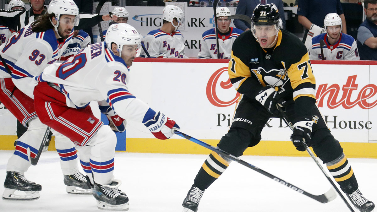 Pittsburgh Penguins center Evgeni Malkin (71) carries the puck against New York Rangers center Mika Zibanejad (93) and left wing Chris Kreider (20) during the first period at PPG Paints Arena.