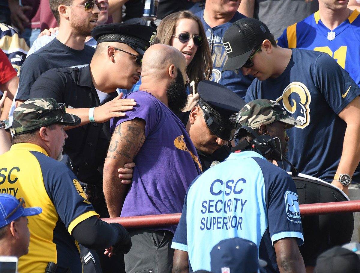Fans are ejected after a fight in the first half of the game between the Los Angeles Rams and the Carolina Panthers at the Los Angeles Memorial Coliseum.