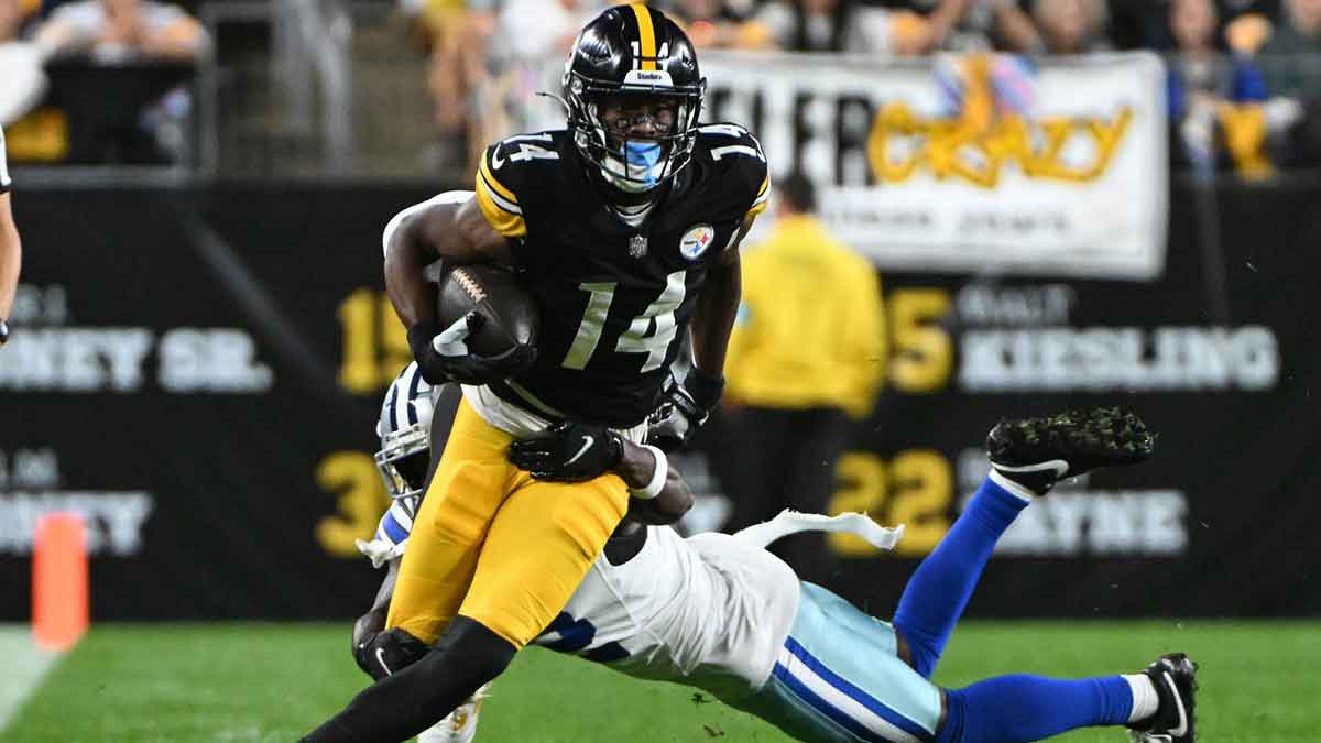 Oct 6, 2024; Pittsburgh, Pennsylvania, USA; Pittsburgh Steelers wide receiver George Pickens (14) breaks a tackle by Dallas Cowboys cornerback Jourdan Lewis (2) during the first quarter at Acrisure Stadium.