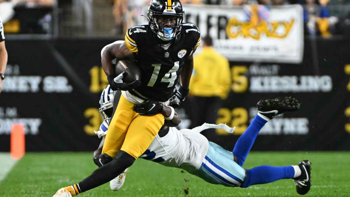 Oct 6, 2024; Pittsburgh, Pennsylvania, USA; Pittsburgh Steelers wide receiver George Pickens (14) breaks a tackle by Dallas Cowboys cornerback Jourdan Lewis (2) during the first quarter at Acrisure Stadium.