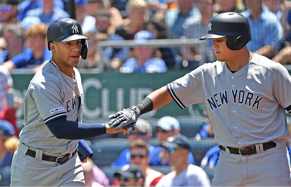 New York Yankees shortstop Gleyber Torres (25) celebrates with Yankees third baseman Gio Urshela (29) after scoring a run during the second inning against the Kansas City Royals at Kauffman Stadium.