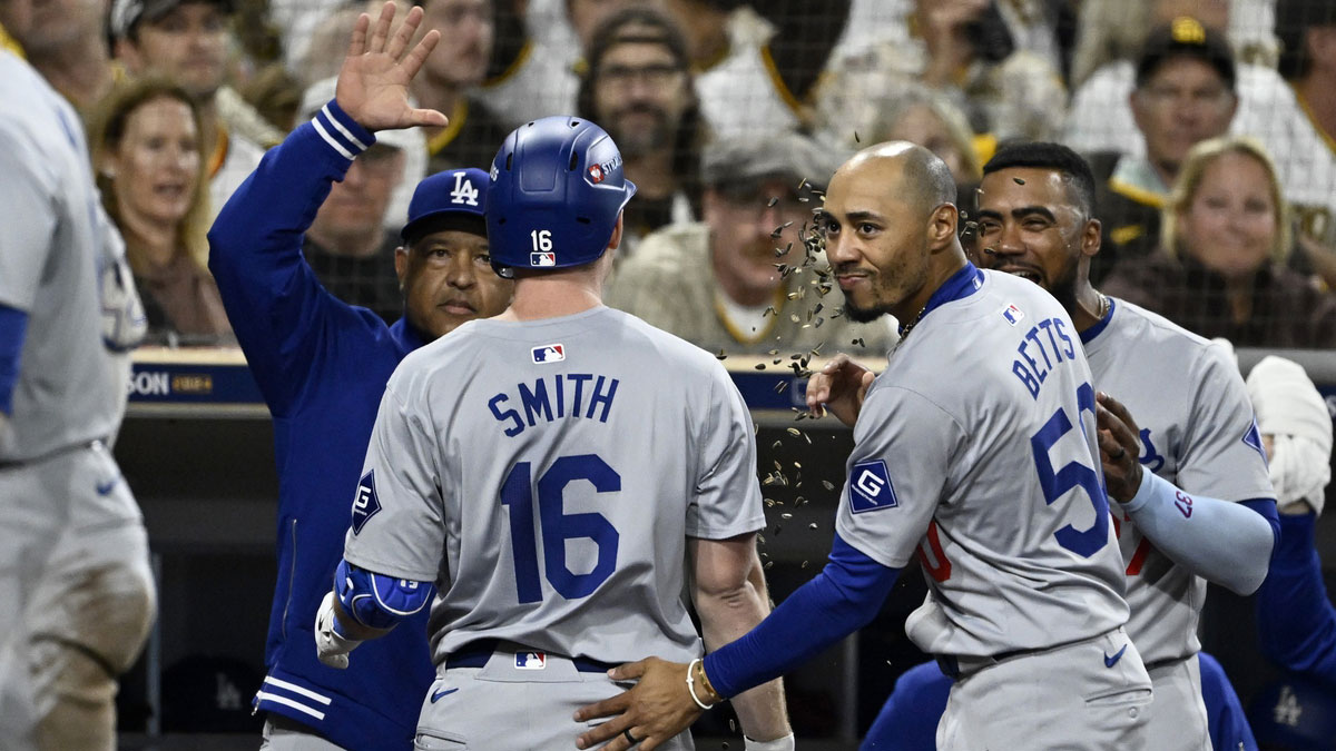 Los Angeles Dodgers catcher Will Smith (16) celebrates with shortstop Mookie Betts (50) and manager Dave Roberts (30) after hitting a two-run home run in the third inning against the San Diego Padres during game four of the NLDS for the 2024 MLB Playoffs at Petco Park.