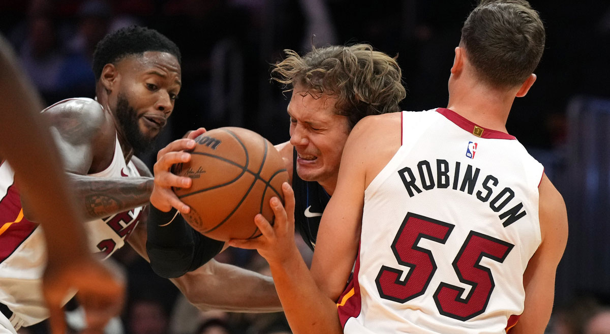 Orlando Magic center Moritz Wagner (21) gets fouled by Miami Heat forward Duncan Robinson (55) as forward Haywood Highsmith (24) closes in during the second half at Kaseya Center.