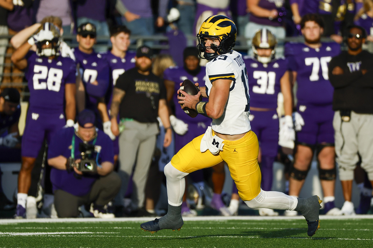 Michigan Wolverines quarterback Jack Tuttle (13) rushes against the Washington Huskies during the second quarter at Alaska Airlines Field at Husky Stadium.