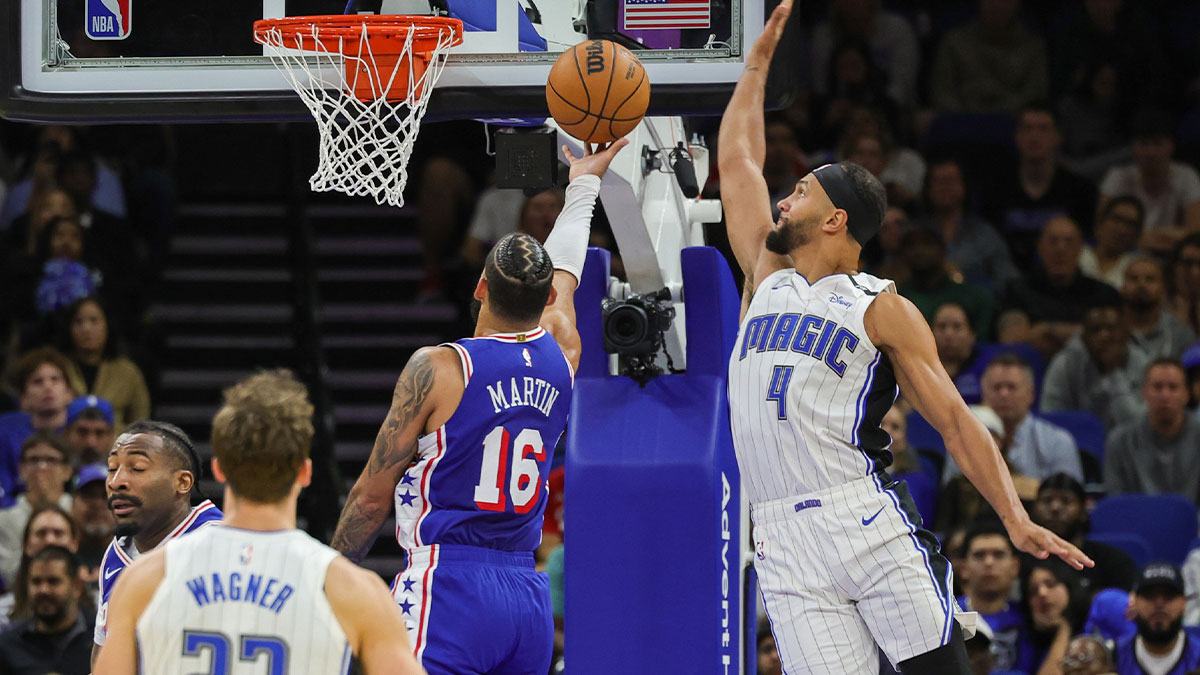 Orlando Magic guard Jalen Suggs (4) blocks a shot by Philadelphia 76ers forward Caleb Martin (16) during the second half at the Kia Center.