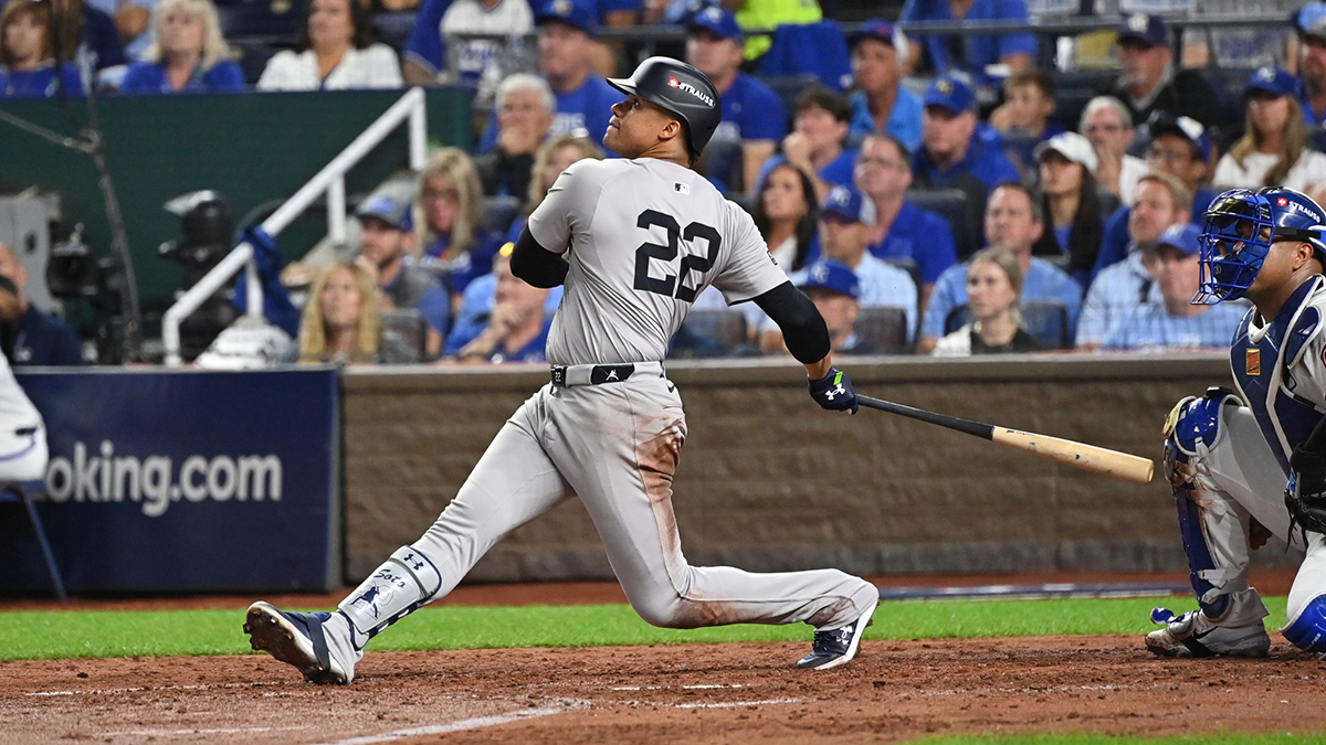New York Yankees outfielder Juan Soto (22) hits a sacrifice fly ball in the fifth inning against the Kansas City Royals during game three of the NLDS for the 2024 MLB Playoffs at Kauffman Stadium.