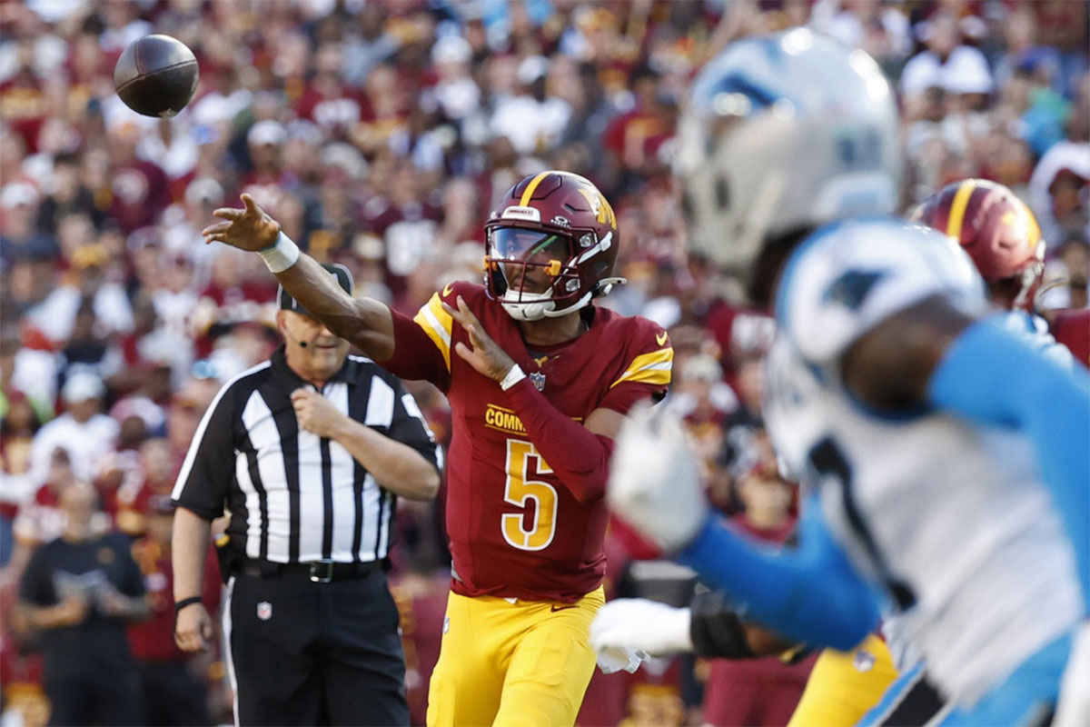 Washington Commanders quarterback Jayden Daniels (5) passes the ball against the Carolina Panthers during the first quarter at Northwest Stadium.