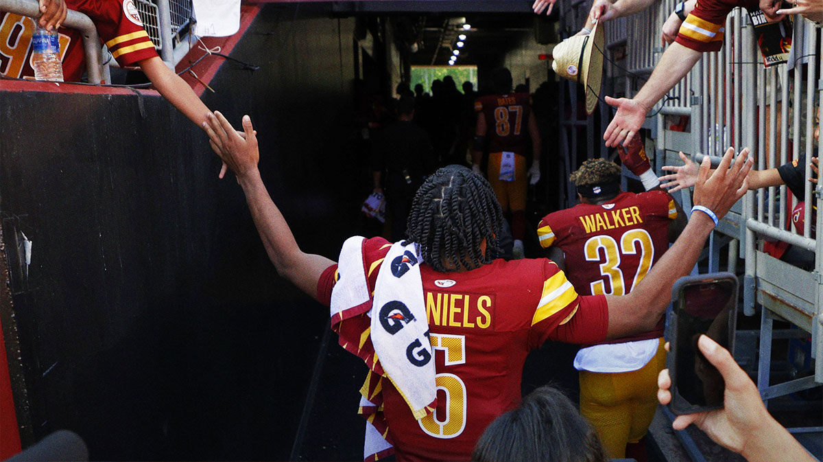 Washington Commanders quarterback Jayden Daniels (5) shakes hands with fans while leaving the field after the game against the Cleveland Browns at NorthWest Stadium.