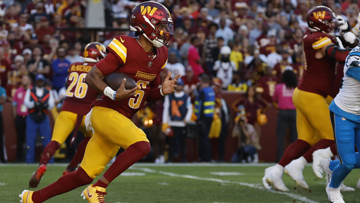 Washington Commanders quarterback Jayden Daniels (5) runs with the ball against the Carolina Panthers during the first quarter at Northwest Stadium.