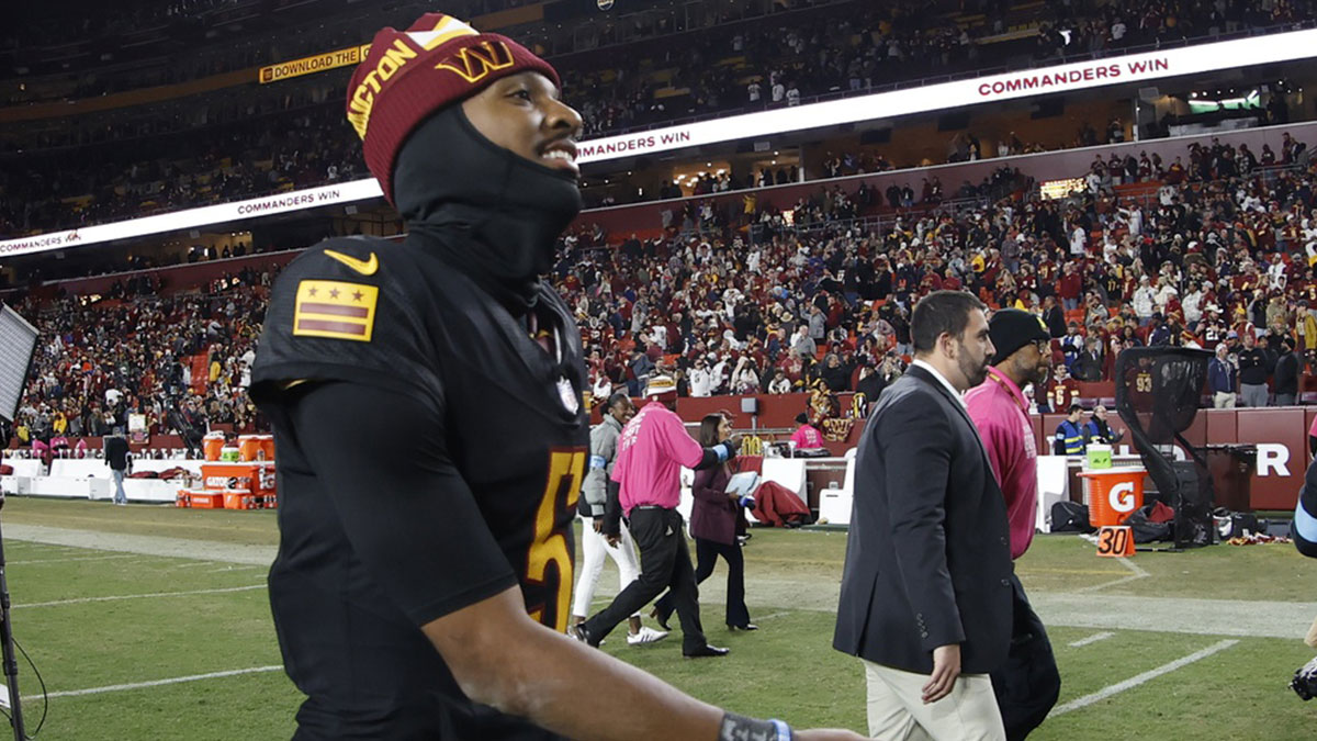 Washington Commanders quarterback Jayden Daniels (5) smiles while leaving the field after the Commanders' game against the Chicago Bears at Northwest Stadium.