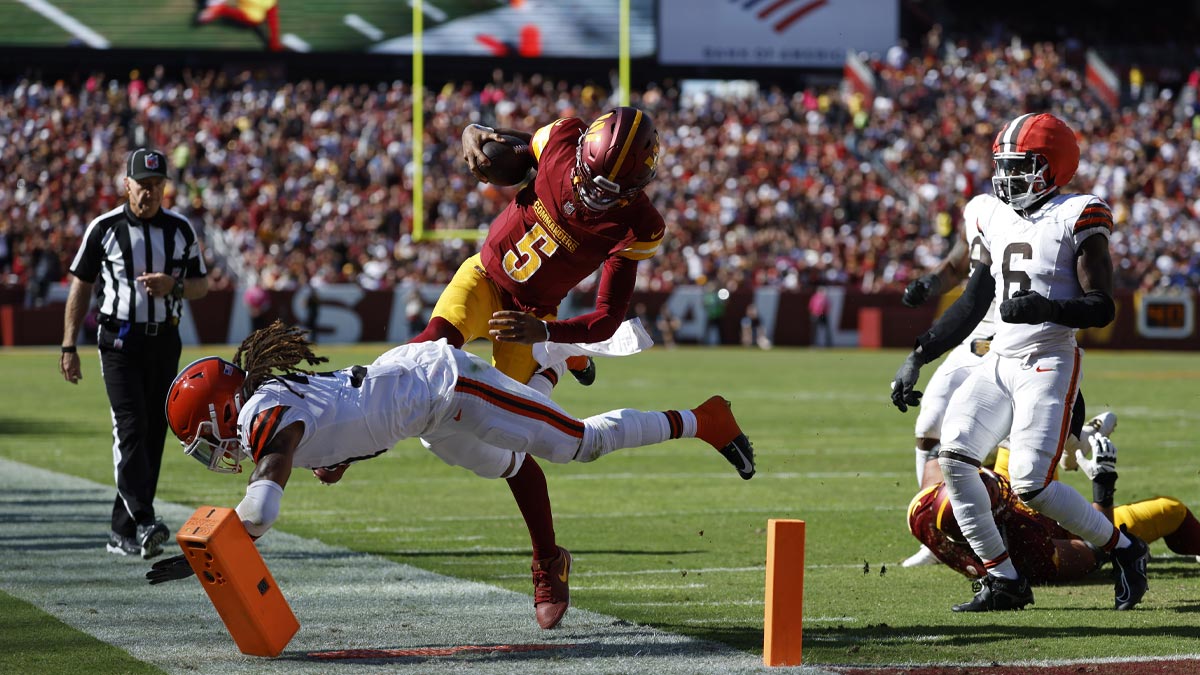 Washington Commanders quarterback Jayden Daniels (5) runs with the ball as Cleveland Browns cornerback Mike Ford Jr. (31) defends during the third quarter at NorthWest Stadium.
