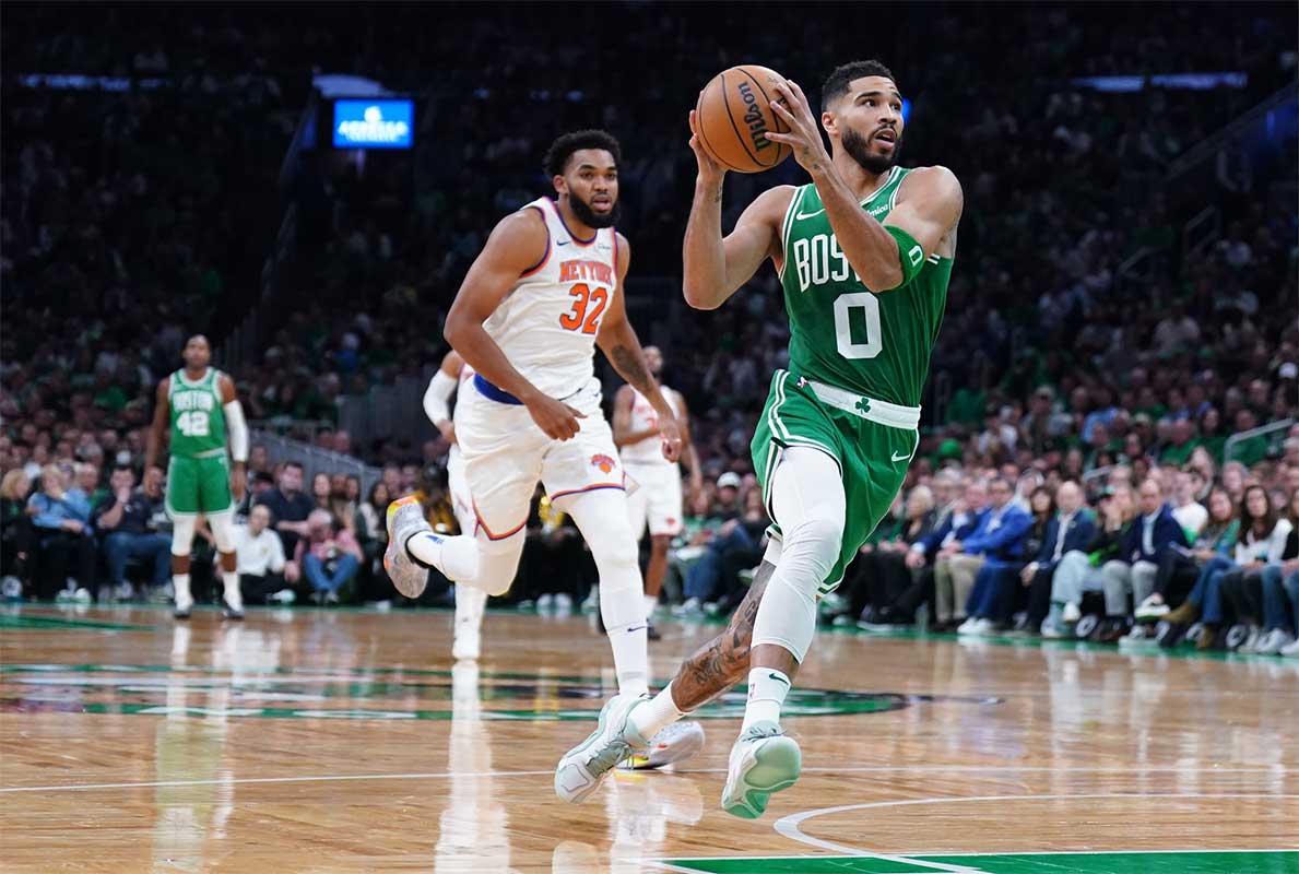 Boston Celtics forward Jayson Tatum (0) returns the ball to score against New York Knicks center Karl-Anthony Towns (32) in the first quarter at TD Garden.
