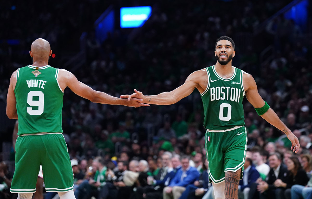 Boston Celtics forward Jayson Tatum (0) reacts with guard Derrick White (9) after a play against the New York Knicks in the second half at TD Garden.