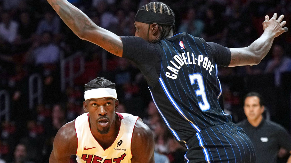 Miami Heat forward Jimmy Butler (22) drives to the basket as Orlando Magic guard Kentavious Caldwell-Pope (3) defends during the first half at Kaseya Center.