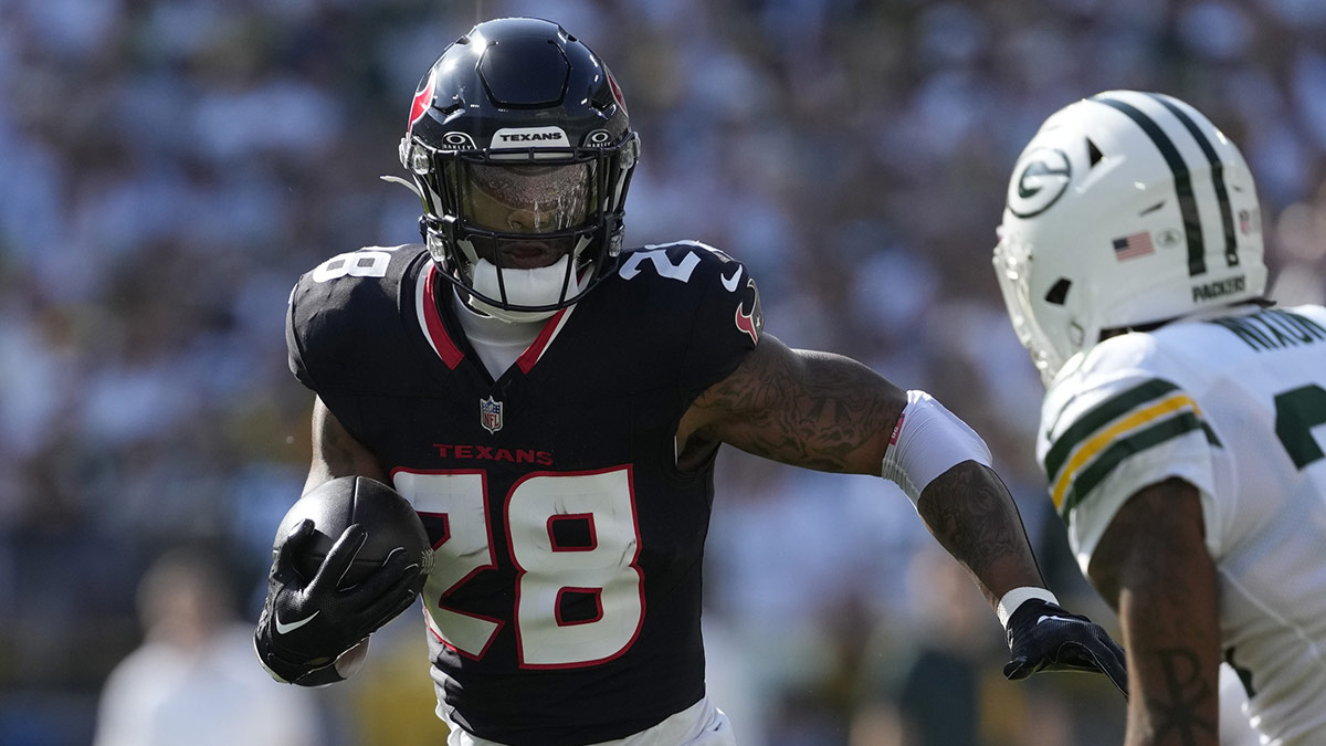 Oct 20, 2024; Green Bay, Wisconsin, USA; Houston Texans running back Joe Mixon (28) rushes with the football against Green Bay Packers cornerback Keisean Nixon (25) during the first quarter at Lambeau Field.