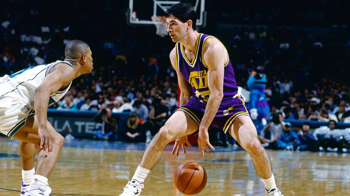 Utah Jazz guard John Stockton (12) is defended by Charlotte Hornets guard Mugsy Bouges (left) at the Charlotte Arena.