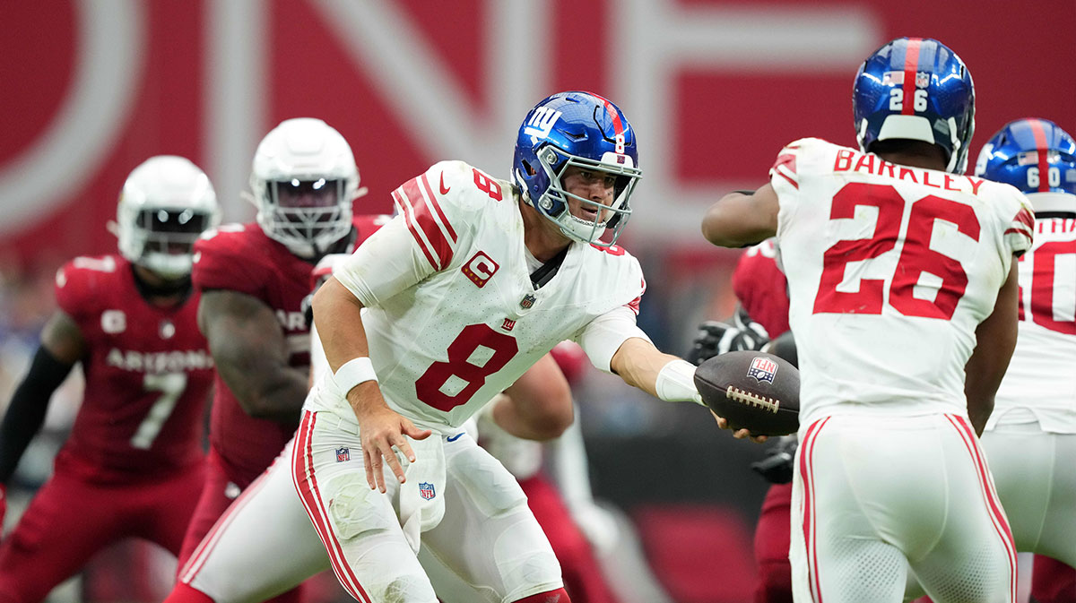 New York Giants quarterback Daniel Jones (8) hands to New York Giants running back Saquon Barkley (26) against the Arizona Cardinals during the second half at State Farm Stadium.