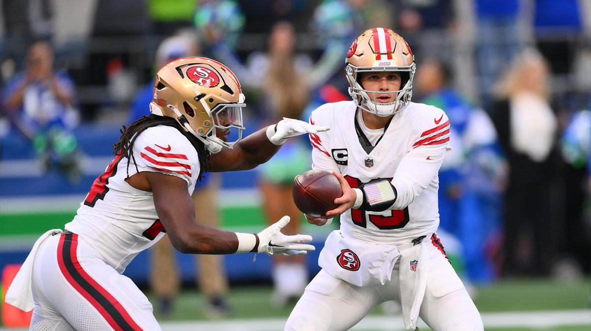 San Francisco 49ers quarterback Brock Purdy (13) hands the ball off to running back Jordan Mason (24) during the first half against the Seattle Seahawks at Lumen Field.