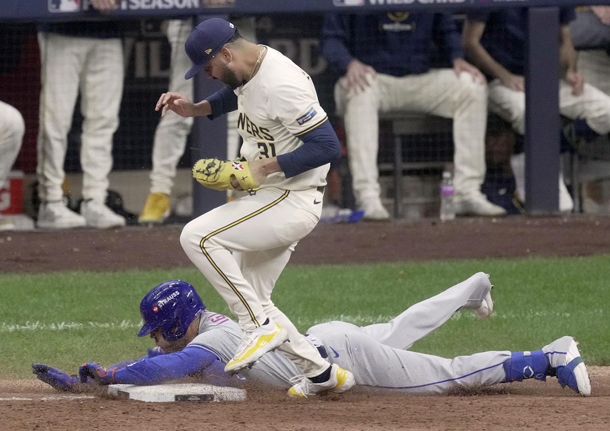 New York Mets second base Jose Iglesias (11) beats a throw at first base to Milwaukee Brewers pitcher Joel Payamps (31) during the fifth inning of their wild-card playoff game against the New York Mets at American Family Field.