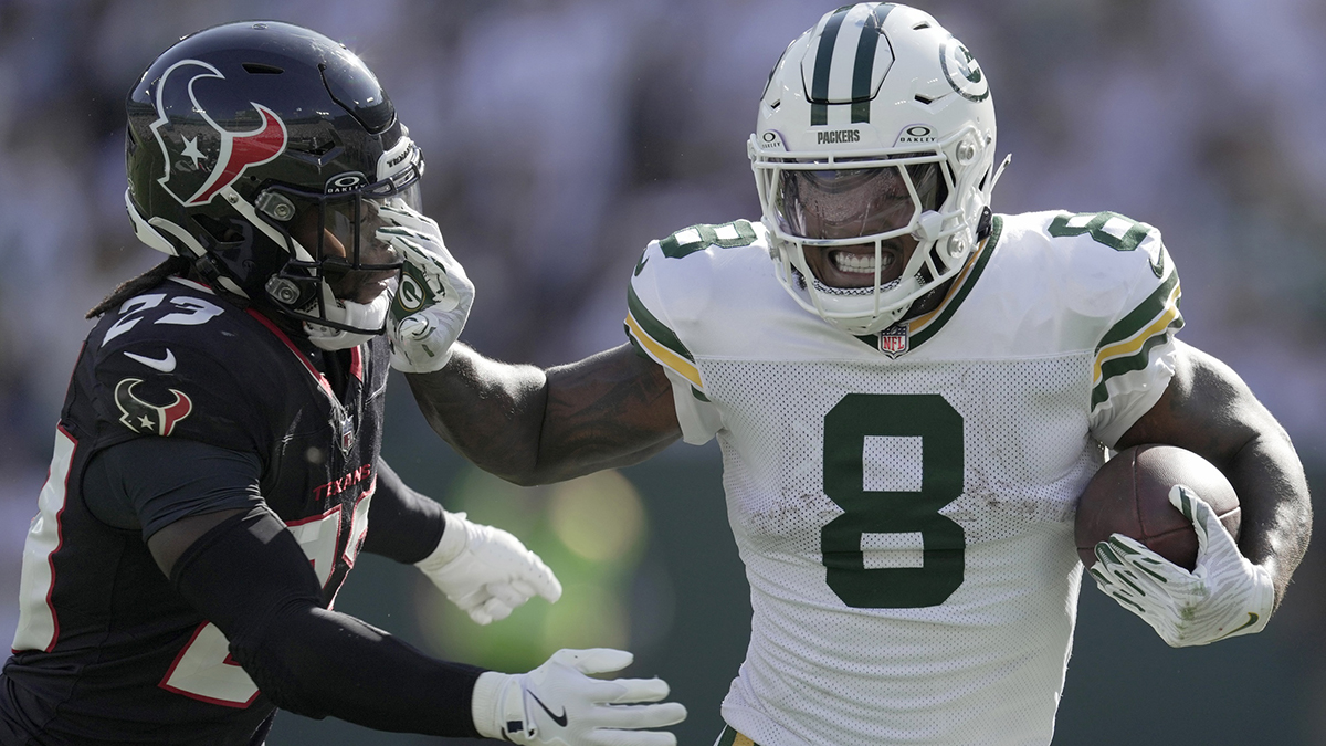 Green Bay Packers running back Josh Jacobs (8) stiff-arms Houston Texans safety Eric Murray (23) during the third quarter of their game at Lambeau Field.
