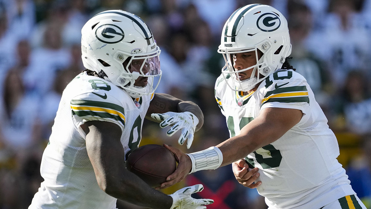  Green Bay Packers quarterback Jordan Love (10) hands the football off to running back Josh Jacobs (8) during the third quarter against the Houston Texans at Lambeau Field.