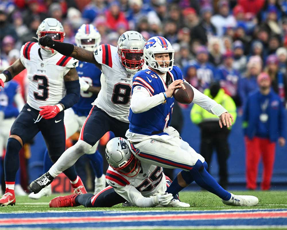 Dec 31, 2023; Orchard Park, New York, USA; Buffalo Bills quarterback Josh Allen (17) is tackled by New England Patriots linebacker Josh Uche (55) and linebacker Ja'Whaun Bentley (8) in the fourth quarter at Highmark Stadium.