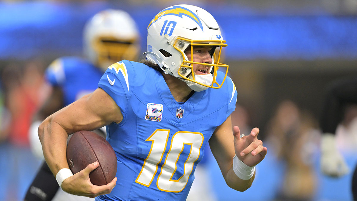 Los Angeles Chargers quarterback Justin Herbert (10) runs for a first down in the first half against the New Orleans Saints at SoFi Stadium.