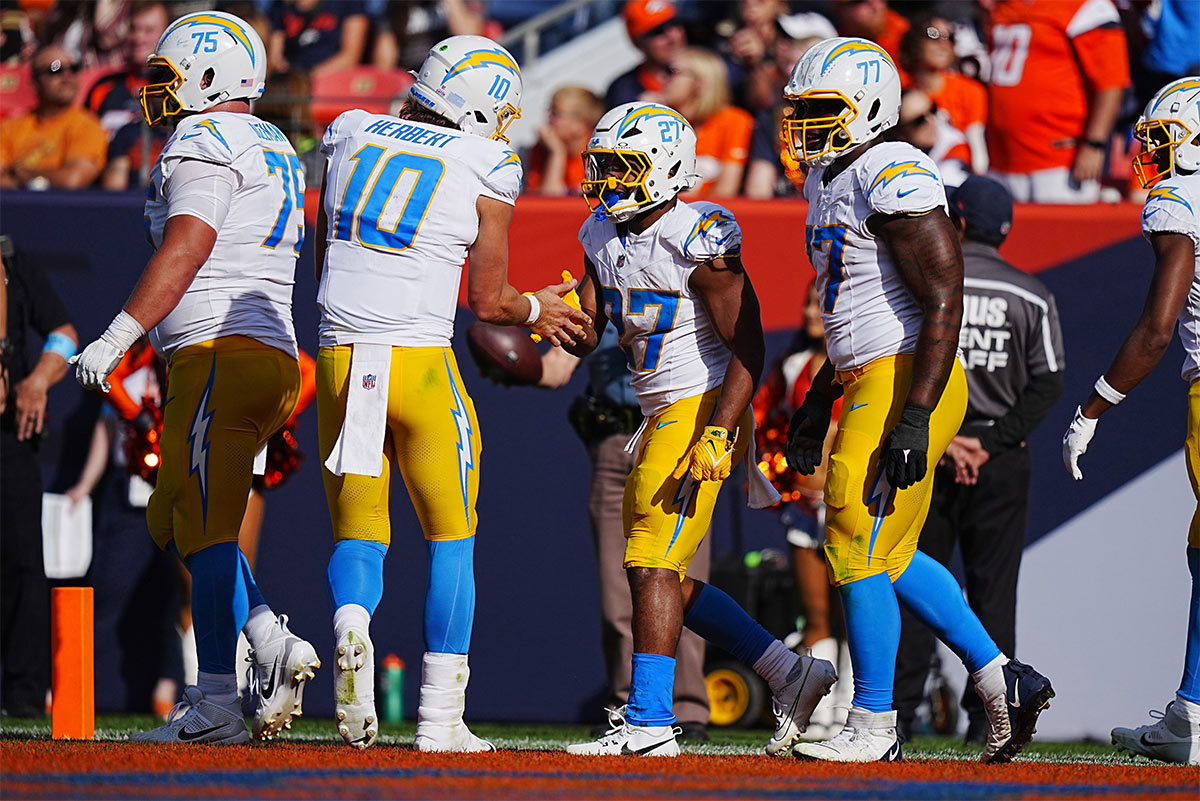Los Angeles Chargers running back J.K. Dobbins (27) celebrates his touchdown carry with quarterback Justin Herbert (10) in the second quarter against the Denver Broncos at Empower Field at Mile High.