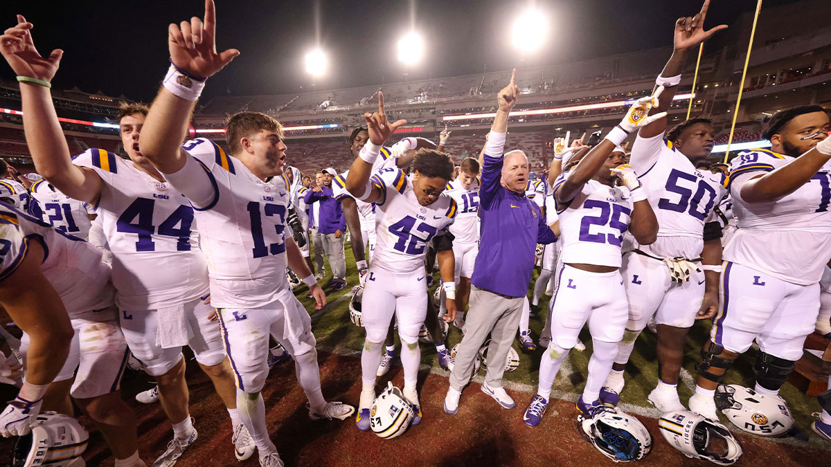 LSU Tigers quarterback Garrett Nussmeier (13) along with teammates and head coach Brian Kelly sing the LSU alma mater after a game against the Arkansas Razorbacks at Donald W. Reynolds Razorback Stadium. LSU won 34-10.