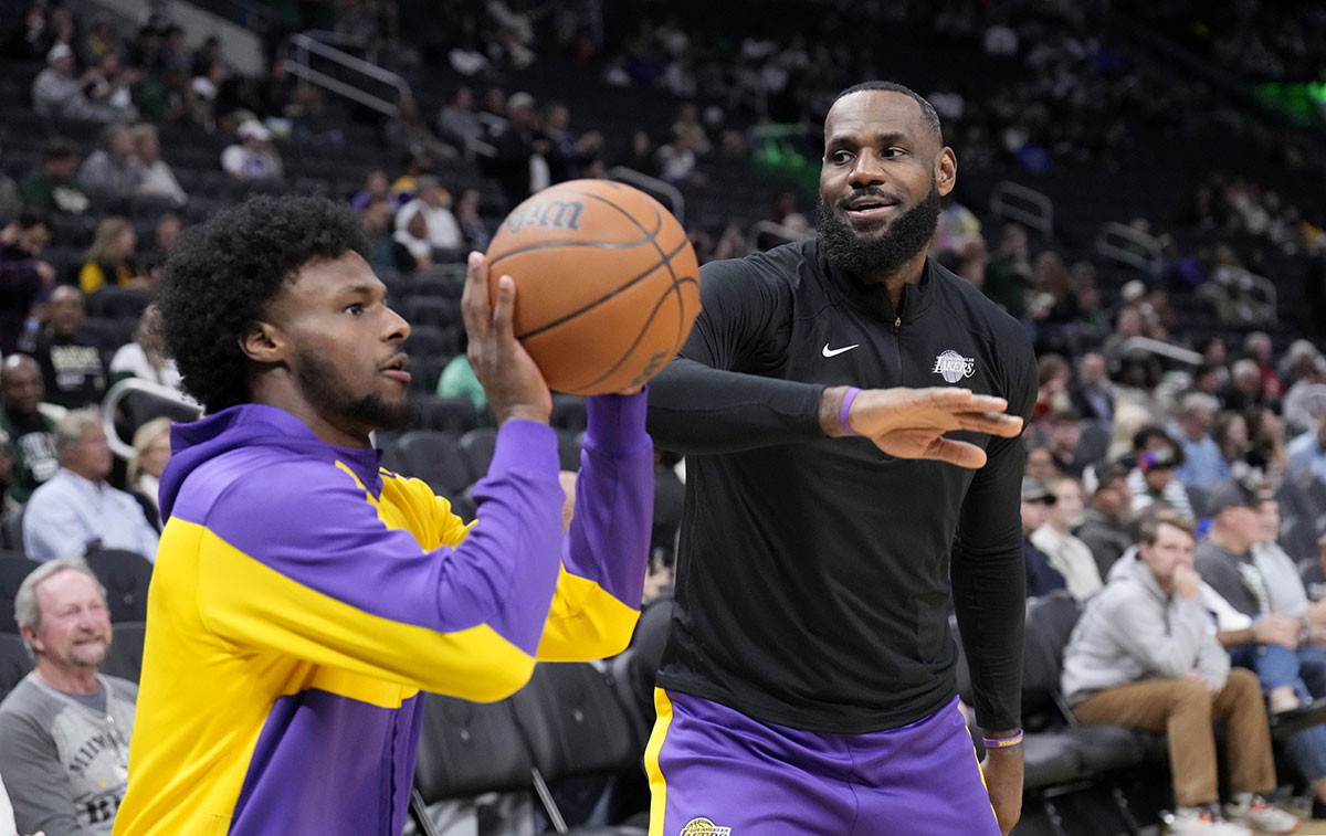 Lakers forward LeBron James (23) jokes with his son Bronny James (9) during warmups before the game against the Milwaukee Bucks at Fiserv Forum