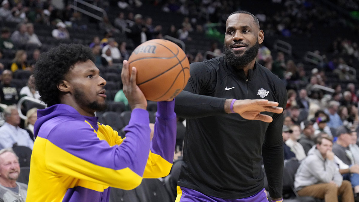 Los Angeles Lakers forward LeBron James (23) goofs around with his son guard Bronny James (9) during warm ups before their game against the Milwaukee Bucks at Fiserv Forum.