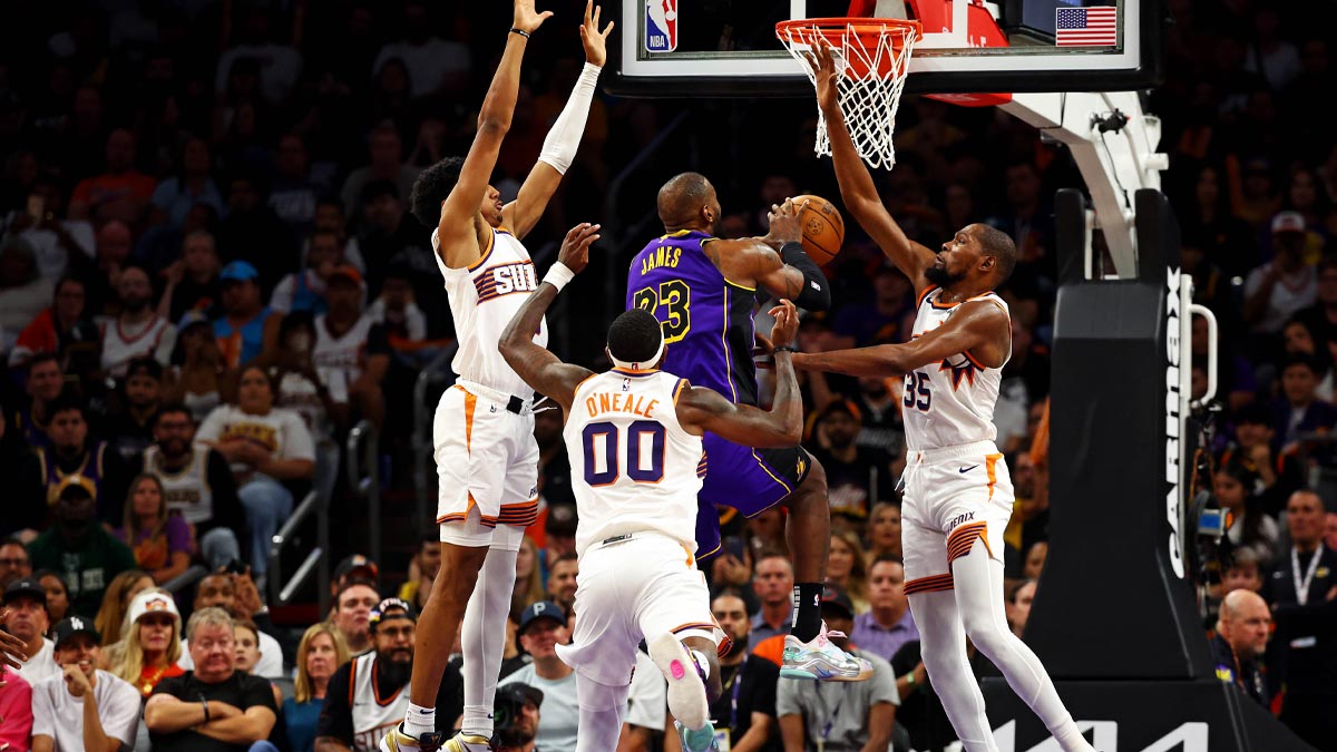 Los Angeles Lakers forward LeBron James (23) shoots the ball against Phoenix Suns forward Ryan Dunn (0), forward Royce O'Neale (00) and forward Kevin Durant (35) during the second half at Footprint Center