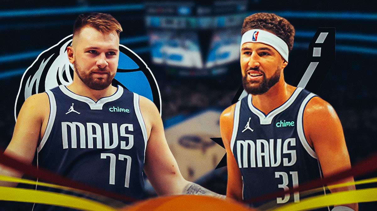 Mavs guard Luka Doncic smiling looking the opposite direction of Mavs guard Klay Thompson shooting next to the Mavs and Spurs logos