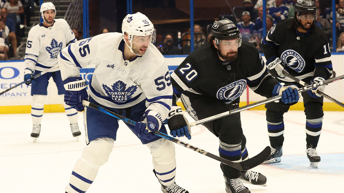 oronto Maple Leafs defenseman Mark Giordano (55) and Tampa Bay Lightning left wing Nicholas Paul (20) skate for a loose puck during the third period at Amalie Arena.
