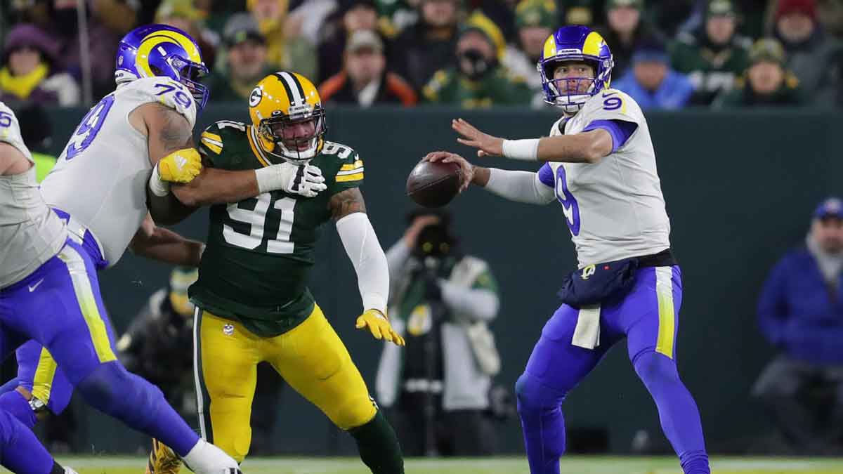 Los Angeles Rams quarterback Matthew Stafford (9) looks to pass as Green Bay Packers outside linebacker Preston Smith (91) tries to shed a block during the second half of the Green Bay Packers 36-28 win at Lambeau Field in Green Bay on Sunday, Nov. 28, 2021.