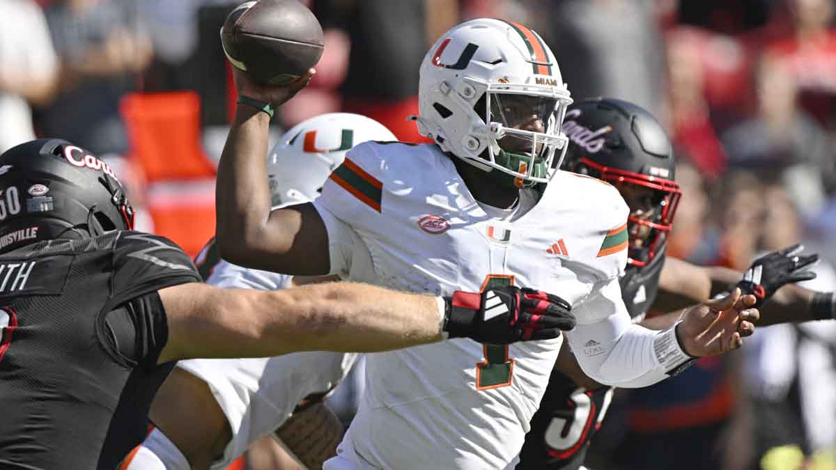 Oct 19, 2024; Louisville, Kentucky, USA; Miami Hurricanes quarterback Cam Ward (1) looks to pass under the pressure of Louisville Cardinals defensive lineman Thor Griffith (50) during the second half at L&N Federal Credit Union Stadium. Miami defeated Louisville 52-45. Mandatory Credit: Jamie Rhodes-Imagn Images