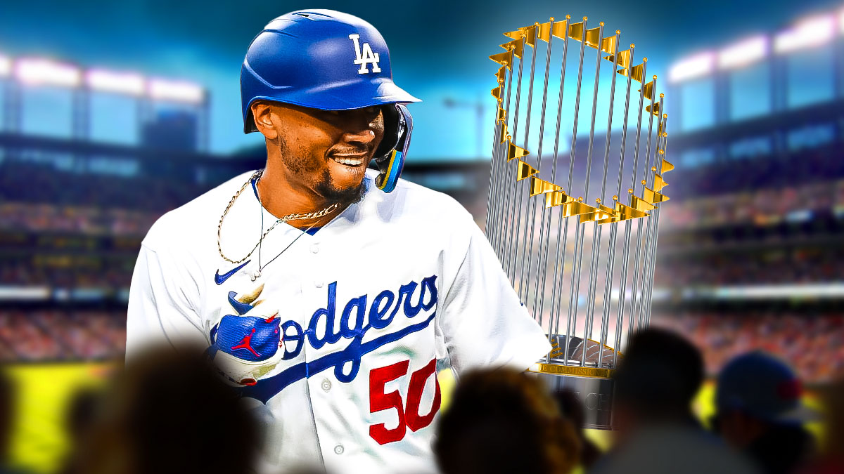 Mookie Betts in a Los Angeles Dodgers uniform celebrating with a World Series trophy in the background as Betts and the Dodgers beat the Yankees in the World Series.