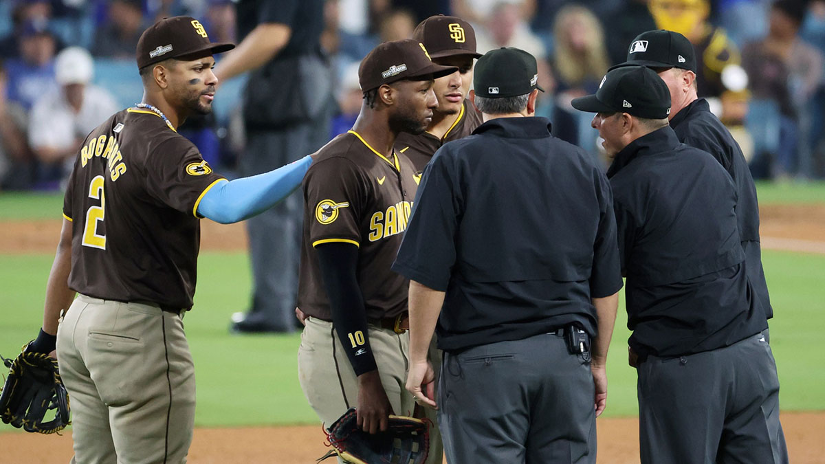 San Diego Padres second baseman Xander Bogaerts (2) and third baseman Manny Machado (13) and outfielder Jurickson Profar (10) talk with umpires in the seventh inning against the Los Angeles Dodgers during game two of the NLDS for the 2024 MLB Playoffs at Dodger Stadium.