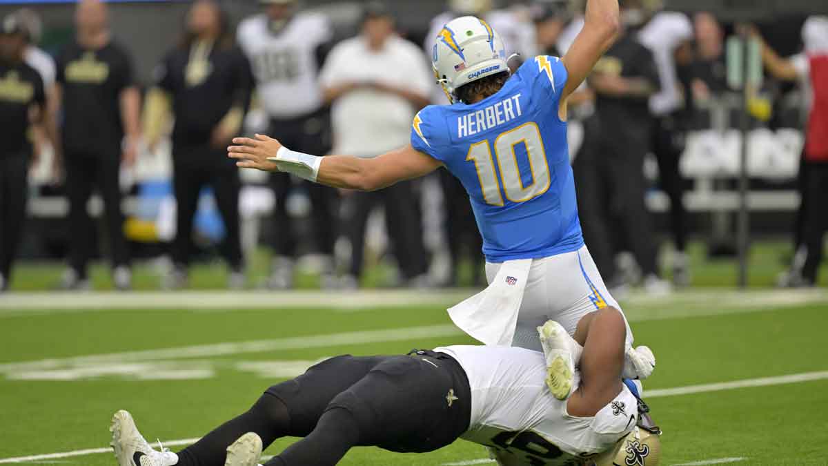 Oct 27, 2024; Inglewood, California, USA; Los Angeles Chargers quarterback Justin Herbert (10) is sacked by New Orleans Saints defensive tackle Nathan Shepherd (93) in the first half at SoFi Stadium.