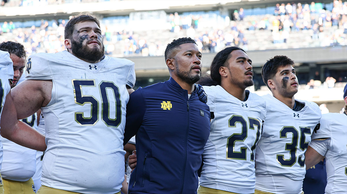 Notre Dame Fighting Irish head coach Marcus Freeman sings the Notre Dame alma mater with teammates after the game against the Navy Midshipmen at MetLife Stadium.