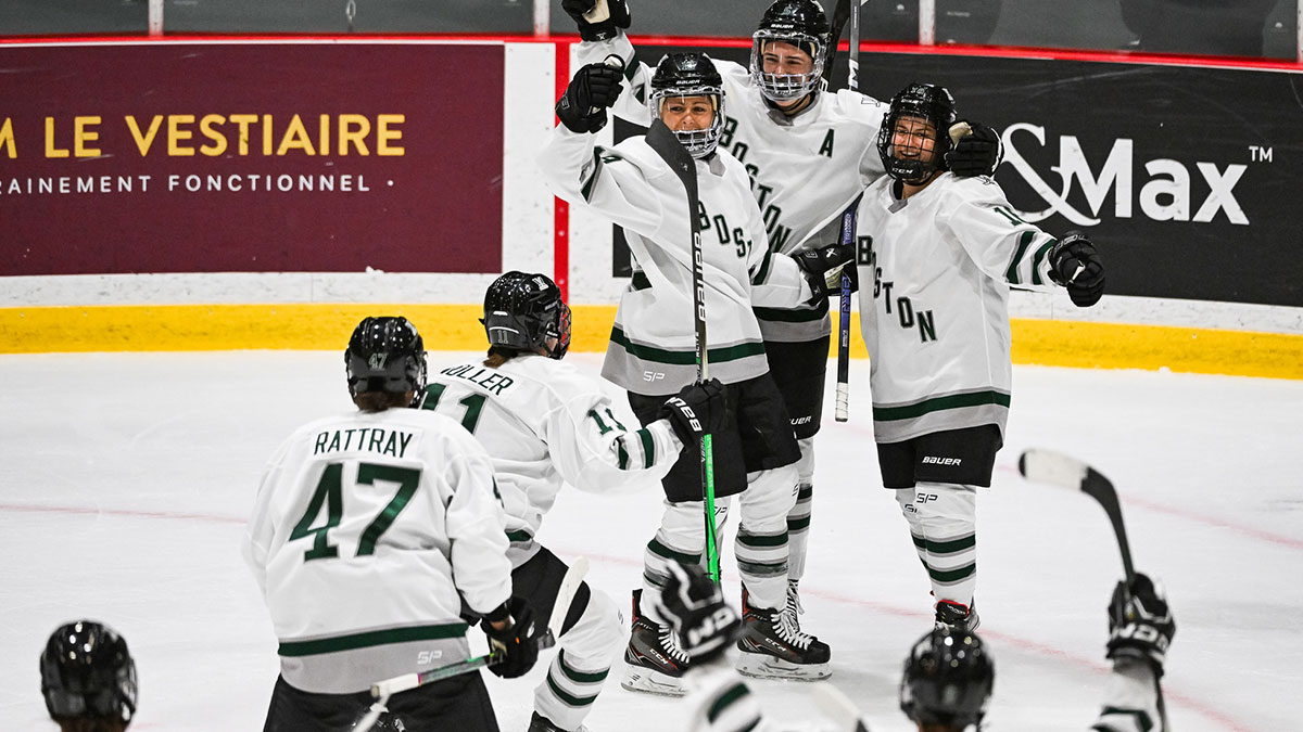 Boston players gather around Boston forward Amanda Pelkey (16) to celebrate the winning goal against Montreal during overtime in a PWHL ice hockey game.