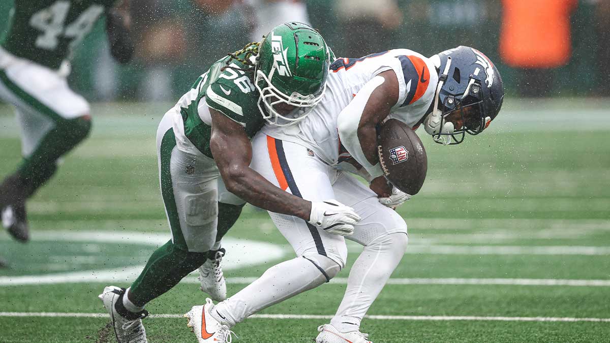 East Rutherford, New Jersey, USA; Denver Broncos running back Tyler Badie (28) fumbles after being hit by New York Jets linebacker Quincy Williams (56) during the first half at MetLife Stadium.