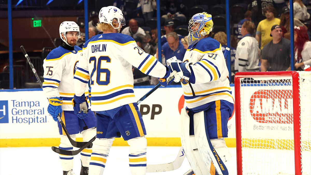 Buffalo Sabres goaltender Eric Comrie (31), defenseman Rasmus Dahlin (26) and defenseman Connor Clifton (75) celebrate after they beat the Tampa Bay Lightning during the third period at Amalie Arena.