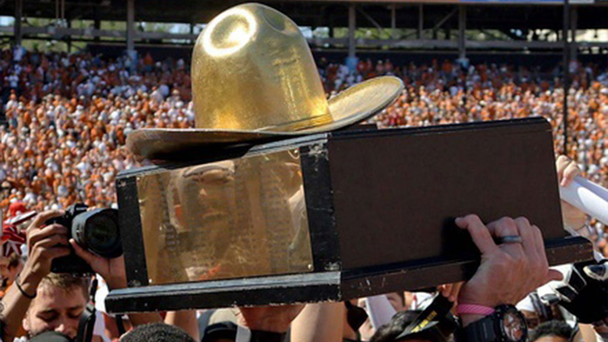 The Golden Hat Trophy is raised after the Red River Rivalry college football game between the University of Oklahoma Sooners (OU) and the University of Texas (UT) Longhorns at the Cotton Bowl