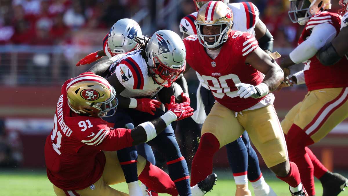 New England Patriots running back Rhamondre Stevenson (38) is tackled by San Francisco 49ers defensive tackle Sam Okuayinonu (91) during the fourth quarter at Levi's Stadium.