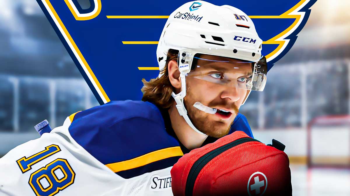 Robert Thomas looking stern, first aid kit, St. Louis Blues logo, hockey rink in background