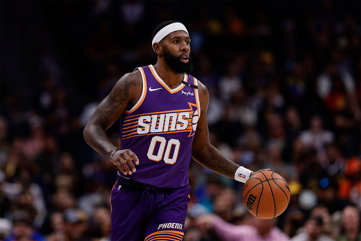 Phoenix Suns forward Royce O'Neale (00) dribbles the ball up court in the first quarter against the Denver Nuggets at Ball Arena.