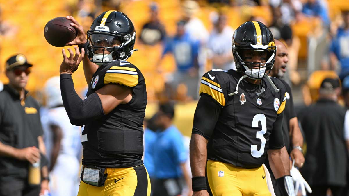 George Pickens in a Pittsburgh Steelers uniform and Russell Wilson in a Pittsburgh Steelers uniform in the background as Wilson is standing up for Pickens after the steelers cut his reps.